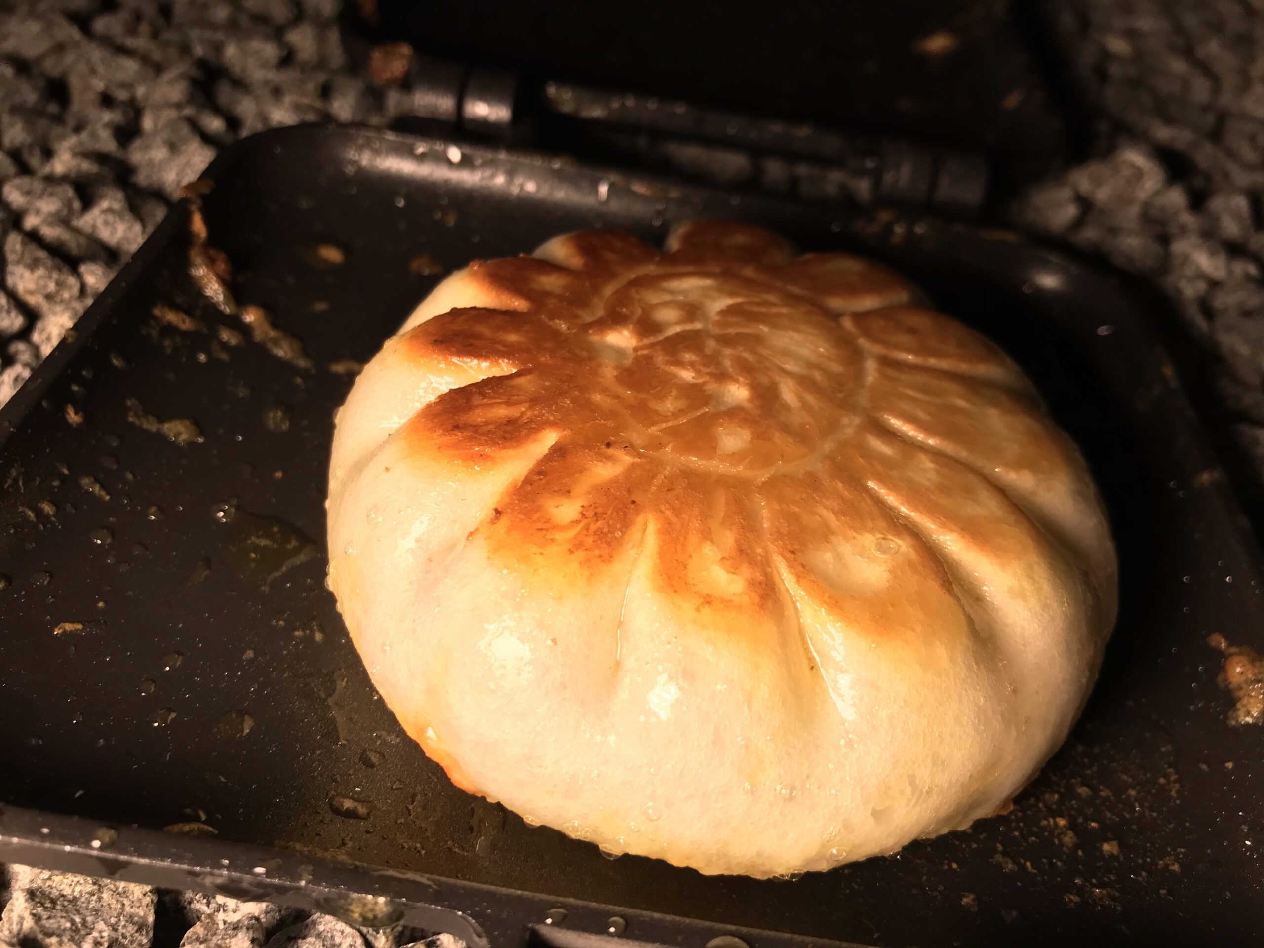 ホットサンドメーカーの上で表面に焼き色がついた肉まん