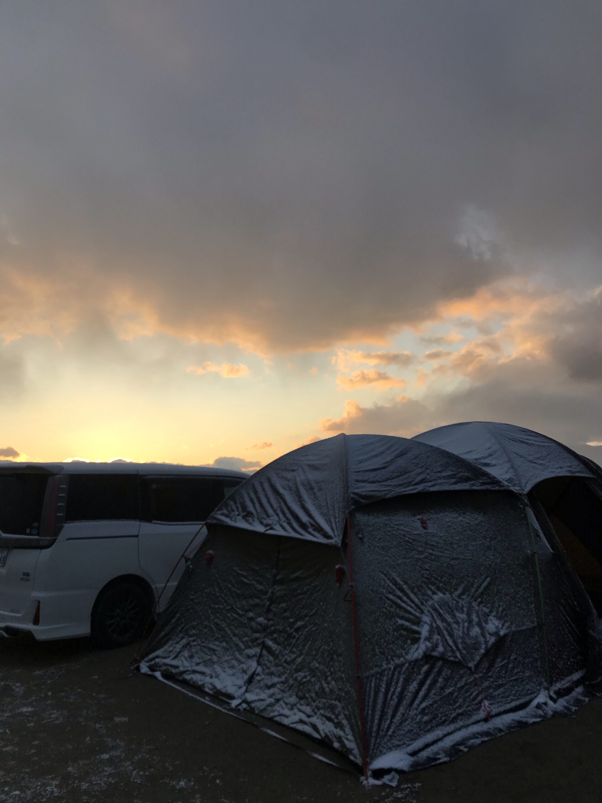 翌朝うっすらと雪が付いたテントと朝焼けの空