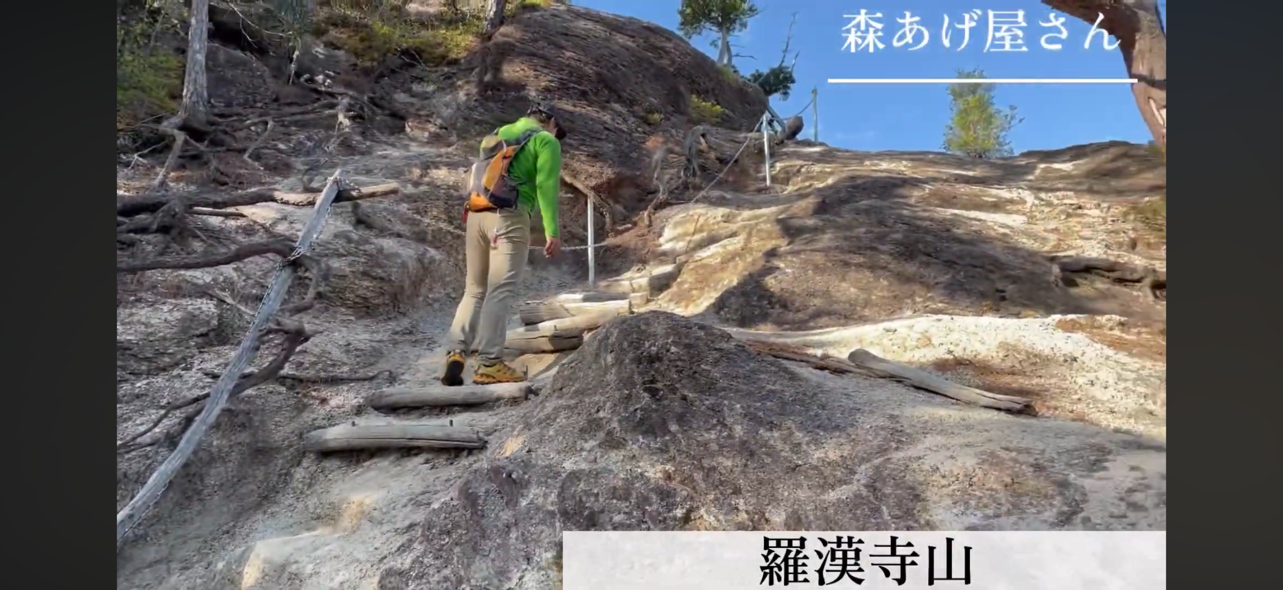 弥三郎岳の岩場を手すり沿いに登る登山者